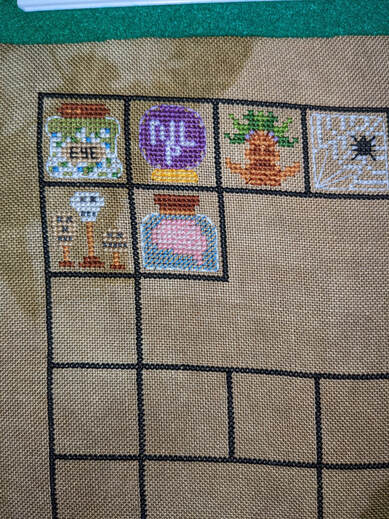 WIP] This is my cross stitch reading goal tracker! After I finish a book, I  fill in one of the books on my bookcase using a colour of thread that  signifies the